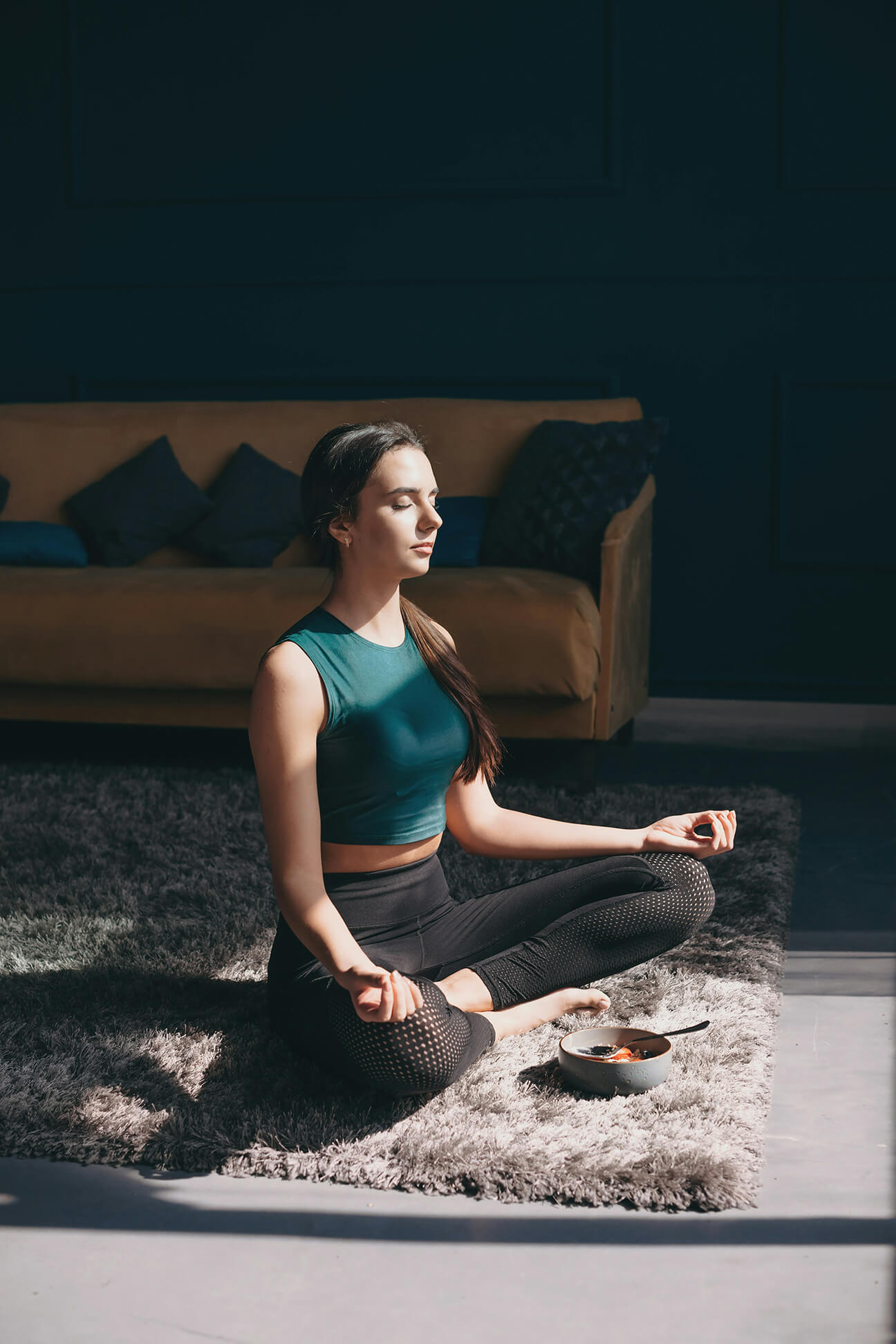 Woman meditating in a room alone.