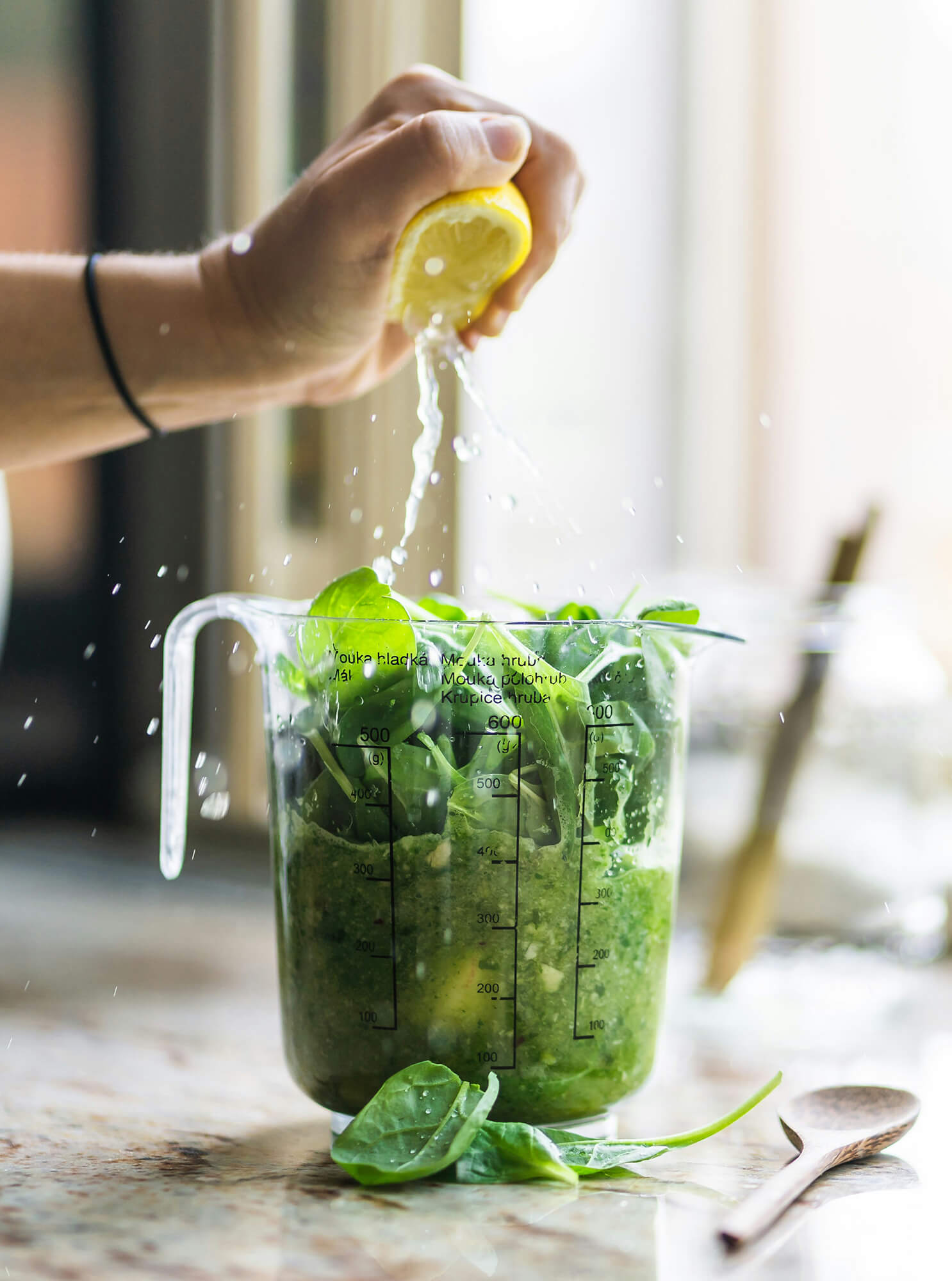 Person squeezing lemon juice onto greens.