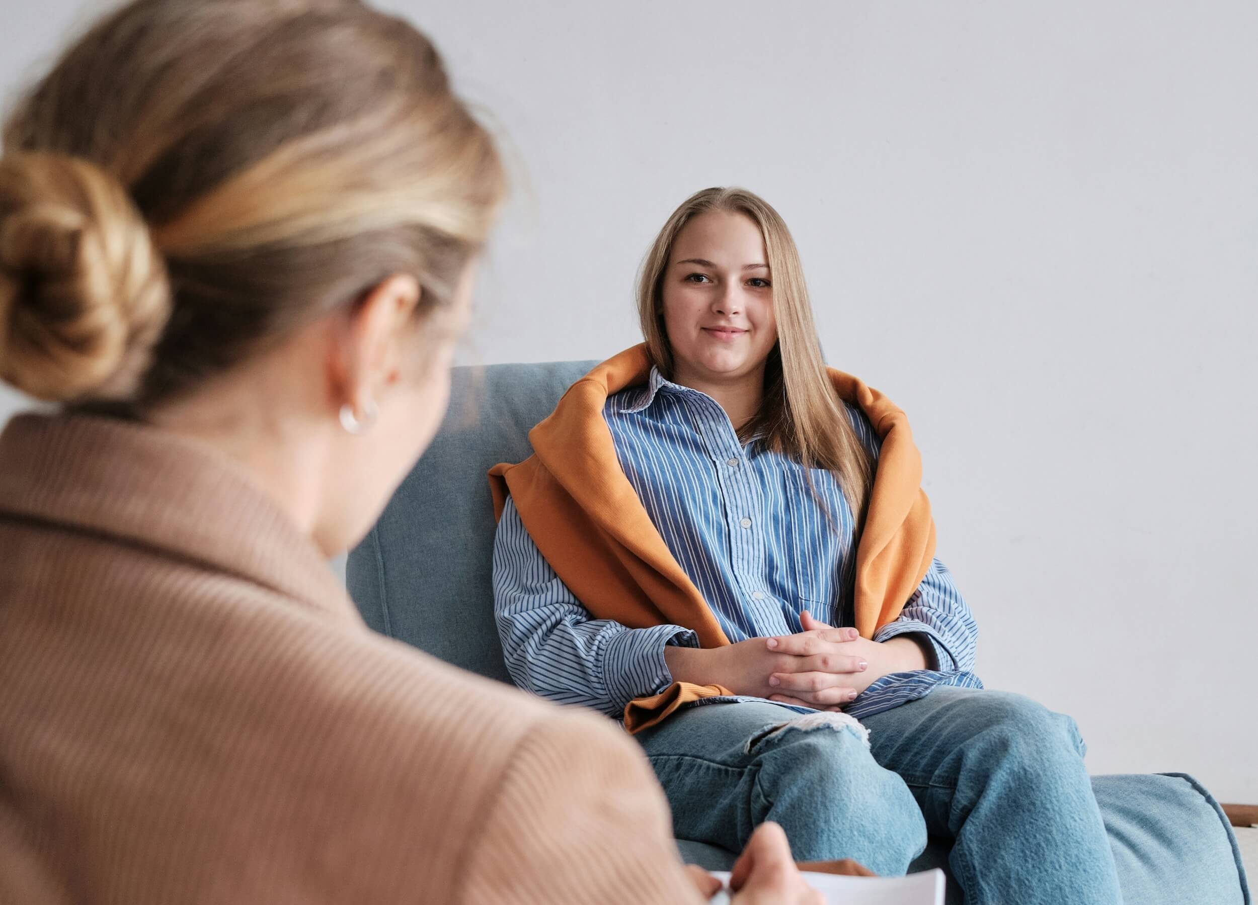 Woman sitting down talking with another woman