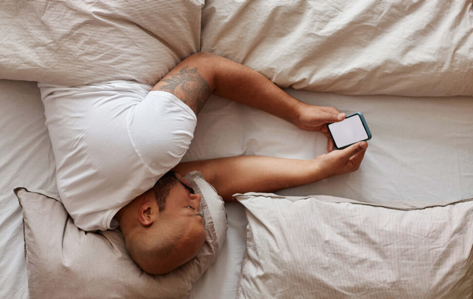 Man lying in bed on phone