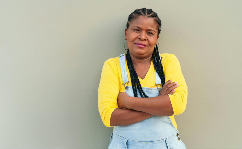 Middle aged woman leaning against wall with arms crossed