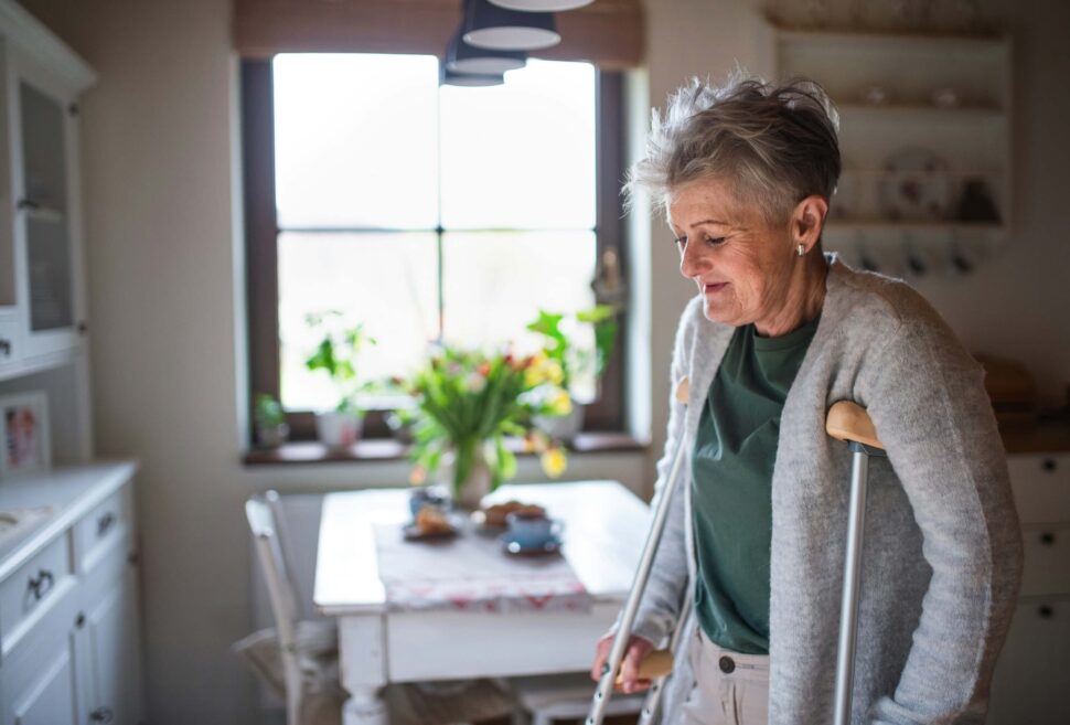 Woman with crutches in her kitchen