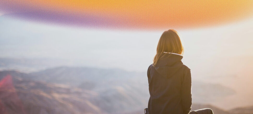 Woman sitting alone in mountains